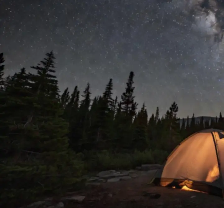 Namiot z przezroczystym dachem widziany nocą pod gwiazdami