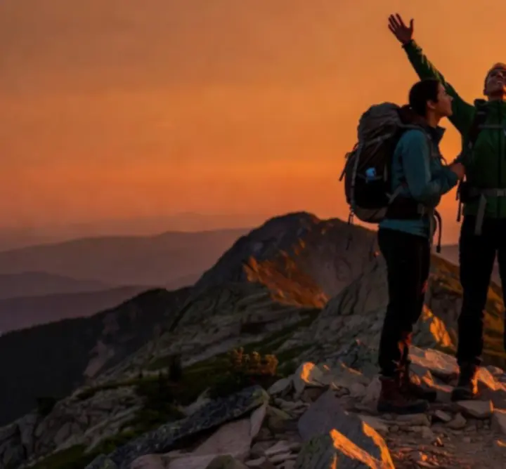 Grupa wędrowców na szczycie górskim z flagą outdooradveenture