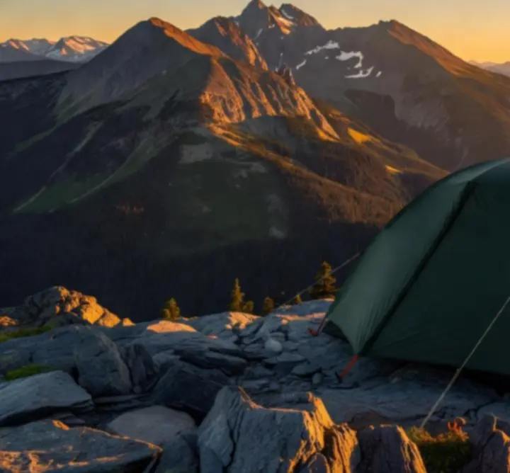Namiot górski oświetlony zachodzącym słońcem w górskim krajobrazie